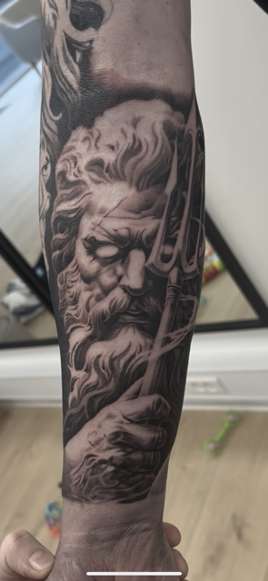 Poseidon i sort/grå realisme på underarm af Christian